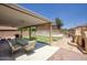 A covered patio and outdoor kitchen with seating, an outdoor fireplace, and a view of the backyard pool at 2210 E Paraiso Dr, Phoenix, AZ 85024