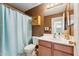 Cozy bathroom with single sink vanity, wood cabinet, and light blue shower curtain at 2432 W Oberlin Way, Phoenix, AZ 85085