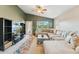 Comfortable living room featuring a sectional sofa, modern entertainment unit, and access to the serene backyard at 2432 W Oberlin Way, Phoenix, AZ 85085