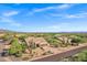 Scenic aerial view of a desert home surrounded by lush greenery and mountain views at 26475 N Wrangler Rd, Scottsdale, AZ 85255