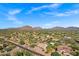 An aerial view of a desert community featuring homes nestled among native trees and natural landscapes at 26475 N Wrangler Rd, Scottsdale, AZ 85255