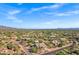 Sweeping aerial vista of a desert neighborhood with custom homes and stunning distant mountain views at 26475 N Wrangler Rd, Scottsdale, AZ 85255