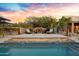 Inviting backyard oasis featuring a fireplace, pool, and covered outdoor kitchen, perfect for entertaining at 26475 N Wrangler Rd, Scottsdale, AZ 85255