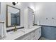 Bright bathroom featuring double sinks, marble countertops, and a decorative blue tile backsplash at 26475 N Wrangler Rd, Scottsdale, AZ 85255