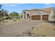 Home's extra-long driveway leads to a three-car garage surrounded by desert landscaping at 26475 N Wrangler Rd, Scottsdale, AZ 85255