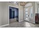 Foyer features a unique light fixture, wood-look tile floors, and clerestory windows at 26475 N Wrangler Rd, Scottsdale, AZ 85255