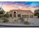 Attractive front exterior of home with desert landscaping, a front yard and a 3 car garage at 26475 N Wrangler Rd, Scottsdale, AZ 85255