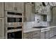 Gourmet kitchen featuring stainless steel appliances, tile backsplash, and stone accent wall at 26475 N Wrangler Rd, Scottsdale, AZ 85255