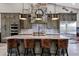 Kitchen island with marble countertop, leather stools, and stainless steel appliances at 26475 N Wrangler Rd, Scottsdale, AZ 85255