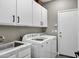 Well-equipped laundry room with white cabinets, a sink, and modern washer and dryer at 26475 N Wrangler Rd, Scottsdale, AZ 85255