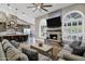 Comfortable living room with stone fireplace, large TV, and modern ceiling fan at 26475 N Wrangler Rd, Scottsdale, AZ 85255