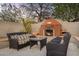 Inviting outdoor seating area with a cozy fireplace, perfect for relaxing and enjoying the tranquil desert ambiance at 26475 N Wrangler Rd, Scottsdale, AZ 85255