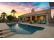 Beautiful backyard with a sparkling pool, covered patio, and lush landscaping at 26475 N Wrangler Rd, Scottsdale, AZ 85255