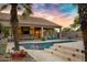 Luxurious backyard with a sparkling pool, covered patio, and lush landscaping, creating a perfect outdoor entertainment space at 26475 N Wrangler Rd, Scottsdale, AZ 85255