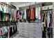 Spacious walk-in closet with gray cabinets, drawers, and ample hanging space for organized storage at 26475 N Wrangler Rd, Scottsdale, AZ 85255