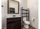 Powder room showcases dark wood vanity, updated fixtures, mirror, and wood look flooring at 278 S San Luis Rey Trl, Casa Grande, AZ 85194