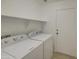 Functional laundry room including a washer, dryer, and overhead shelving at 29384 N Rosewood Dr, San Tan Valley, AZ 85143