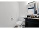 Powder room with dark vanity, black countertop, gold fixtures, and white walls at 2946 N 14Th St # 37, Phoenix, AZ 85014