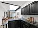 Bright kitchen featuring black cabinets, marble countertops, and an open layout with view to the staircase at 2946 N 14Th St # 37, Phoenix, AZ 85014