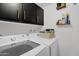 Laundry room with shelving, white front load washer and dryer, and upper cabinets at 2946 N 14Th St # 37, Phoenix, AZ 85014