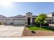 Attractive single-Gathering home featuring a three-car garage and manicured front yard with green grass and decorative rock at 3026 N 305Th Dr, Buckeye, AZ 85396