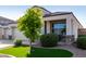 Charming exterior with tidy desert landscaping, a green lawn accent, and a covered porch area at 3026 N 305Th Dr, Buckeye, AZ 85396