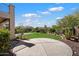 Lush backyard featuring a grassy area, desert landscaping, and a circular concrete patio for outdoor entertaining at 4416 W Magellan Dr, New River, AZ 85087