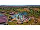 Aerial view of the community pool featuring waterslides, lounge chairs, and colorful umbrellas at 4416 W Magellan Dr, New River, AZ 85087