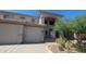 Inviting front exterior showcasing a three car garage, neutral color palette, and desert landscaping at 4416 W Magellan Dr, New River, AZ 85087