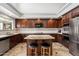 Well-equipped kitchen featuring dark wood cabinets, granite countertops, and stainless steel appliances at 4416 W Magellan Dr, New River, AZ 85087