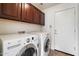 Functional laundry room with dark wood cabinets and a side-by-side washer and dryer at 4416 W Magellan Dr, New River, AZ 85087