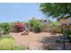 Residential backyard with trees, shrubs, rock landscaping and a water fountain at 4609 W Challenger Trl, New River, AZ 85087