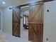 Stylish wooden barn doors lead to the dining room with a glimpse into living spaces at 4609 W Challenger Trl, New River, AZ 85087