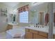 Bright bathroom featuring dual sinks, a soaking tub, and a separate shower at 4609 W Challenger Trl, New River, AZ 85087