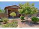 Landscaped front yard with colorful flowering bushes, gravel, and mature trees at 4609 W Challenger Trl, New River, AZ 85087