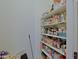 Organized walk-in pantry features white shelving stocked with a variety of food items and household goods at 4609 W Challenger Trl, New River, AZ 85087