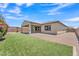 Expansive backyard featuring a covered patio, artificial grass, and desert landscaping, ideal for outdoor entertaining at 4866 N 185-Th Dr, Goodyear, AZ 85395