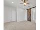 Bedroom featuring carpet, ceiling fan, and a sliding barn door at 4866 N 185-Th Dr, Goodyear, AZ 85395