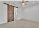 Bedroom with rustic sliding barn door and carpet flooring at 4866 N 185-Th Dr, Goodyear, AZ 85395