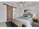 This bedroom features a barn door entrance to bathroom, neutral tones, and stylish furnishings at 4866 N 185-Th Dr, Goodyear, AZ 85395