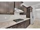 Close-up of kitchen showcasing gas cooktop, granite countertops, and dark cabinets with stainless steel accents at 4866 N 185-Th Dr, Goodyear, AZ 85395