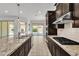 Beautiful kitchen with stainless steel appliances, granite counters, dark cabinets, and an open view to outdoor patio at 4866 N 185-Th Dr, Goodyear, AZ 85395