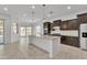 Modern kitchen featuring stainless steel appliances, granite countertops, a breakfast bar, and dark wood cabinetry at 4866 N 185-Th Dr, Goodyear, AZ 85395