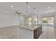 Spacious kitchen island with stainless steel sink, opening to a large living area and backyard patio at 4866 N 185-Th Dr, Goodyear, AZ 85395