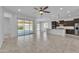 Open-concept living area seamlessly connecting the living room, dining area, and kitchen with modern tile floors at 4866 N 185-Th Dr, Goodyear, AZ 85395