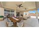 This covered patio features ample seating, ceiling fans, and sliding glass doors for indoor/outdoor living at 4866 N 185-Th Dr, Goodyear, AZ 85395
