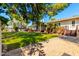 A lush backyard with a well-maintained lawn, mature trees, and a patio with desert landscaping at 5744 E Oak St, Scottsdale, AZ 85257
