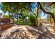 A lush backyard featuring desert landscaping, mature trees, lush greenery, and a well-maintained patio at 5744 E Oak St, Scottsdale, AZ 85257