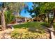 A well-maintained lush backyard featuring a lawn, mature trees, desert landscaping, and a patio at 5744 E Oak St, Scottsdale, AZ 85257