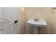 Classic pedestal sink in a well-lit powder room with white walls and trim at 5744 E Oak St, Scottsdale, AZ 85257
